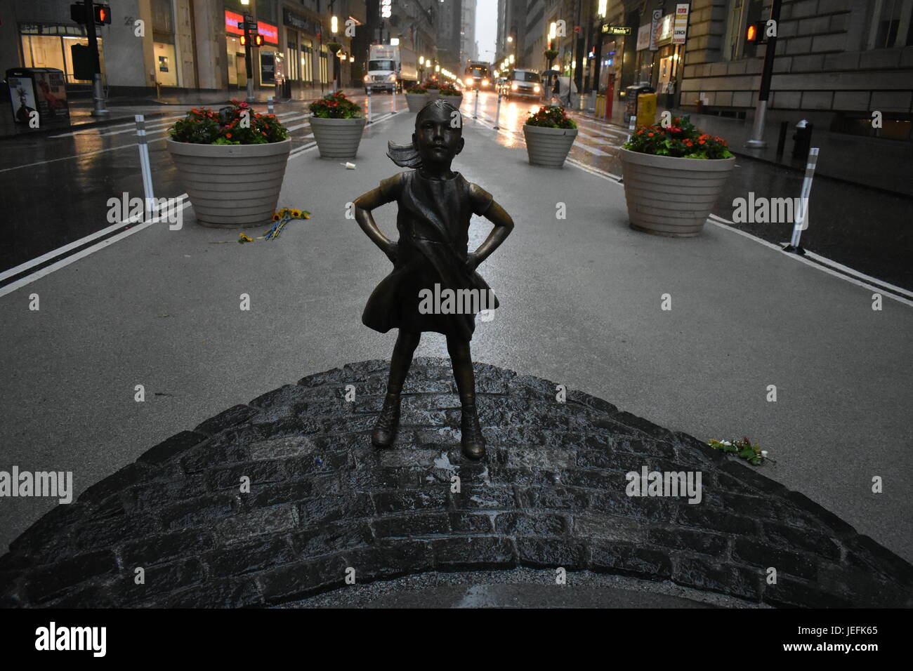 Furchtlose Mädchen starrt hinunter Wall Street Bull Stockfoto