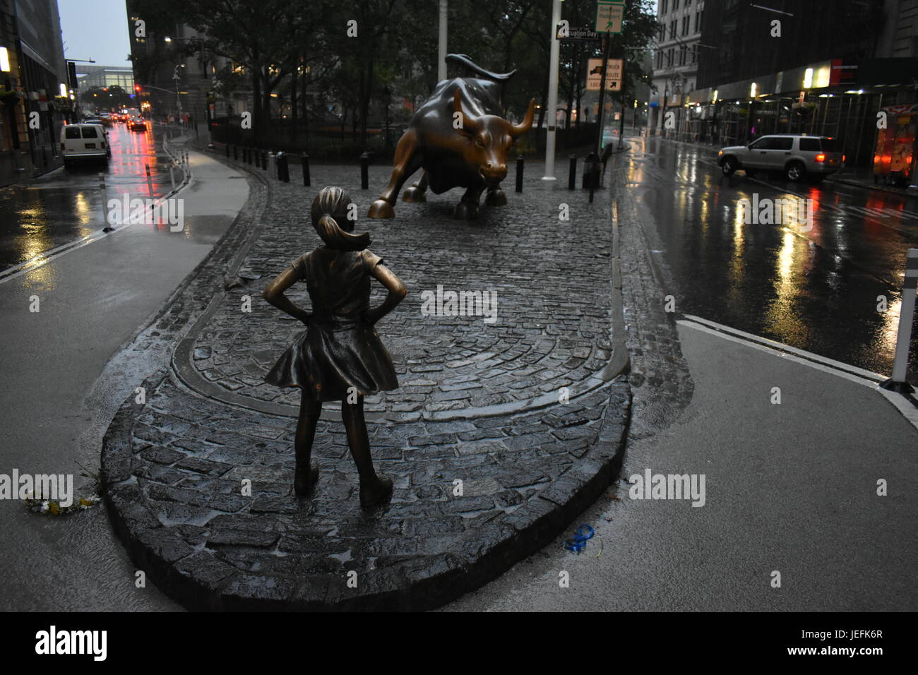 Furchtlose Mädchen starrt hinunter Wall Street Bull Stockfoto