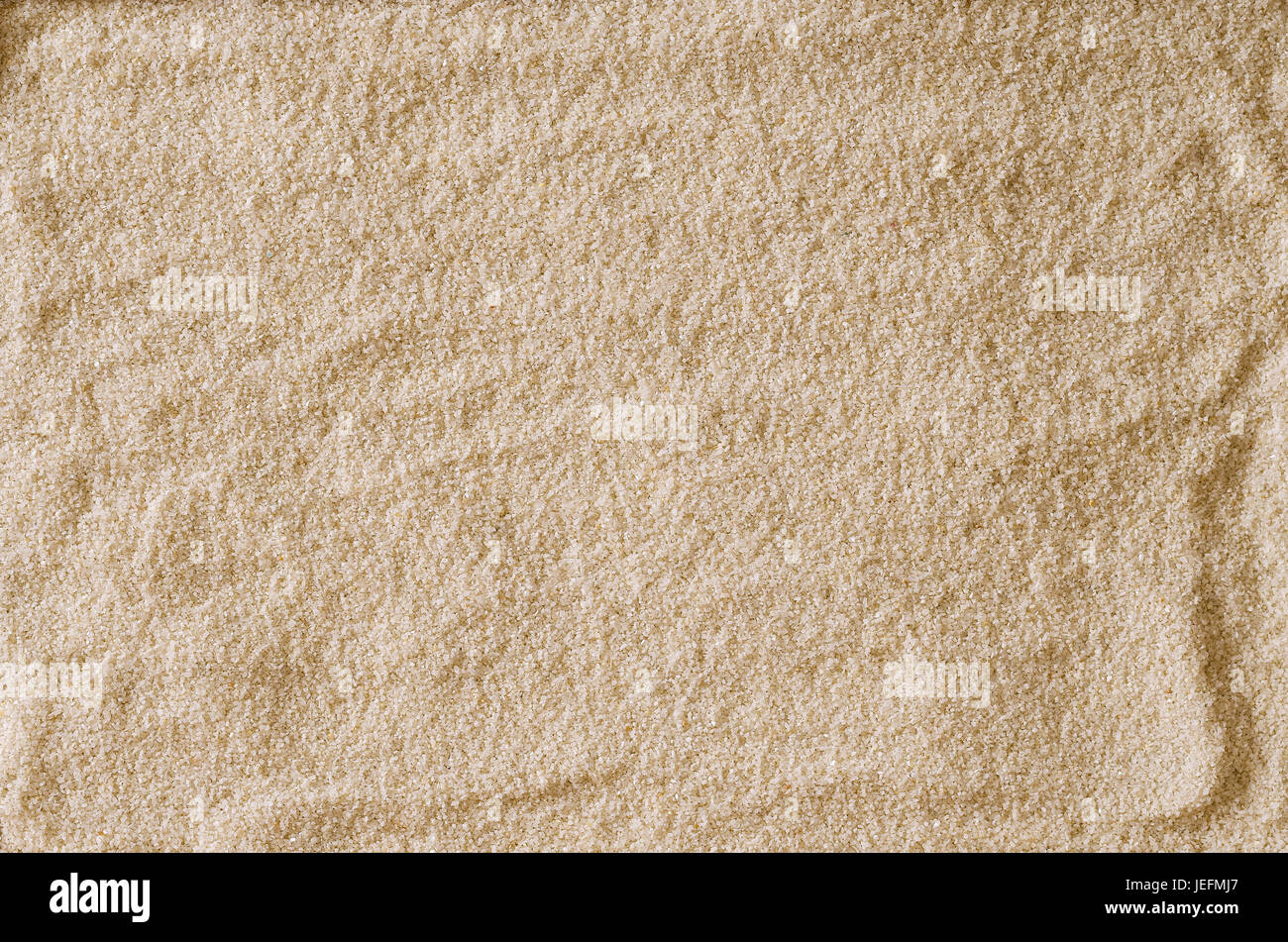 Rau und uneben leer Sandoberfläche als Hintergrund oder als Textur verwenden. Hell braun und Ocker gefärbt Sandkörner. Makrofoto Nahaufnahme von oben. Stockfoto