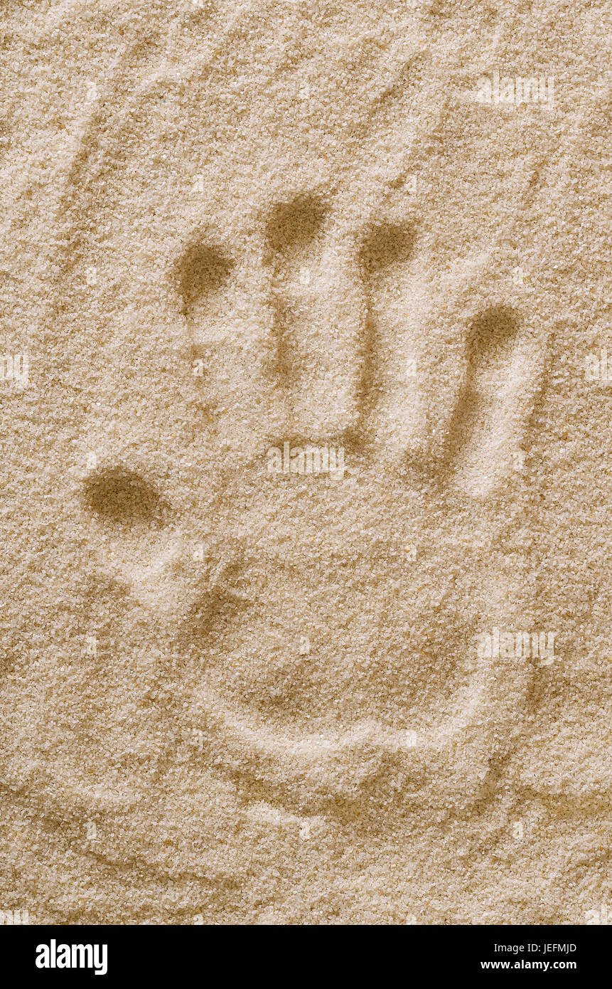 Handabdruck in Sand. Handmark und Abdruck der linken Hand eines Erwachsenen in Trinkwasserbehältern Sand trocken. Makrofoto Nahaufnahme von oben. Stockfoto