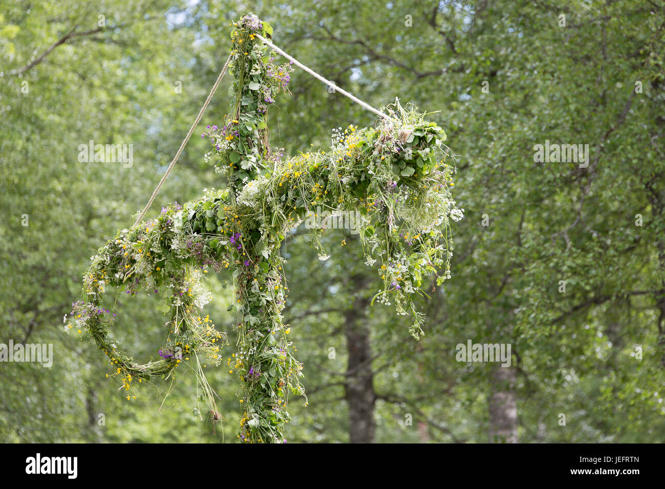 Schwedische Maibaum mit Blumen bedeckt. Stockfoto