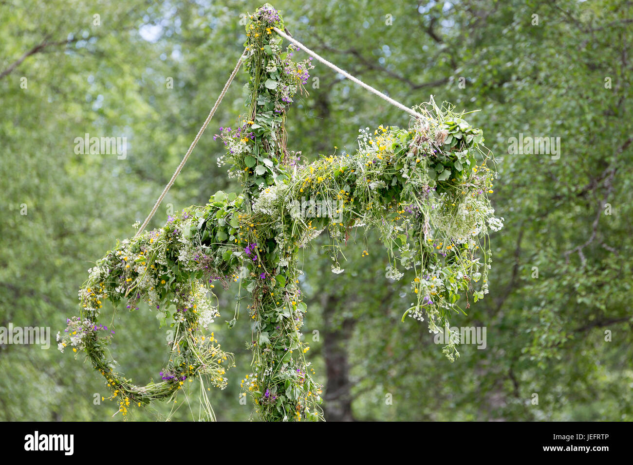 Schwedische Maibaum mit Blumen bedeckt. Stockfoto