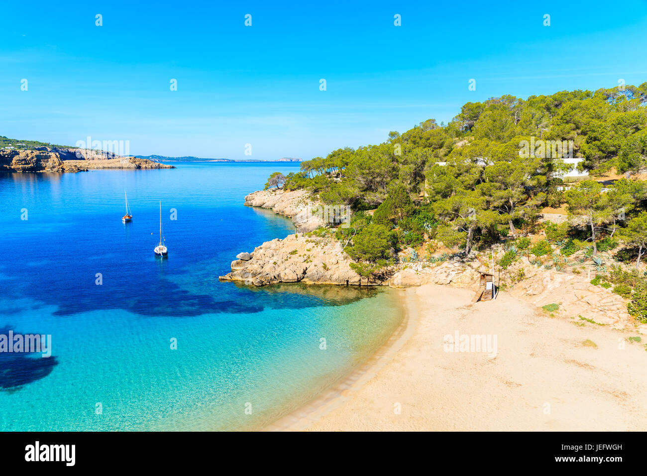Blick auf den schönen Strand in Cala Salada berühmt für seine Azure kristallklares Meerwasser, Insel Ibiza, Spanien Stockfoto