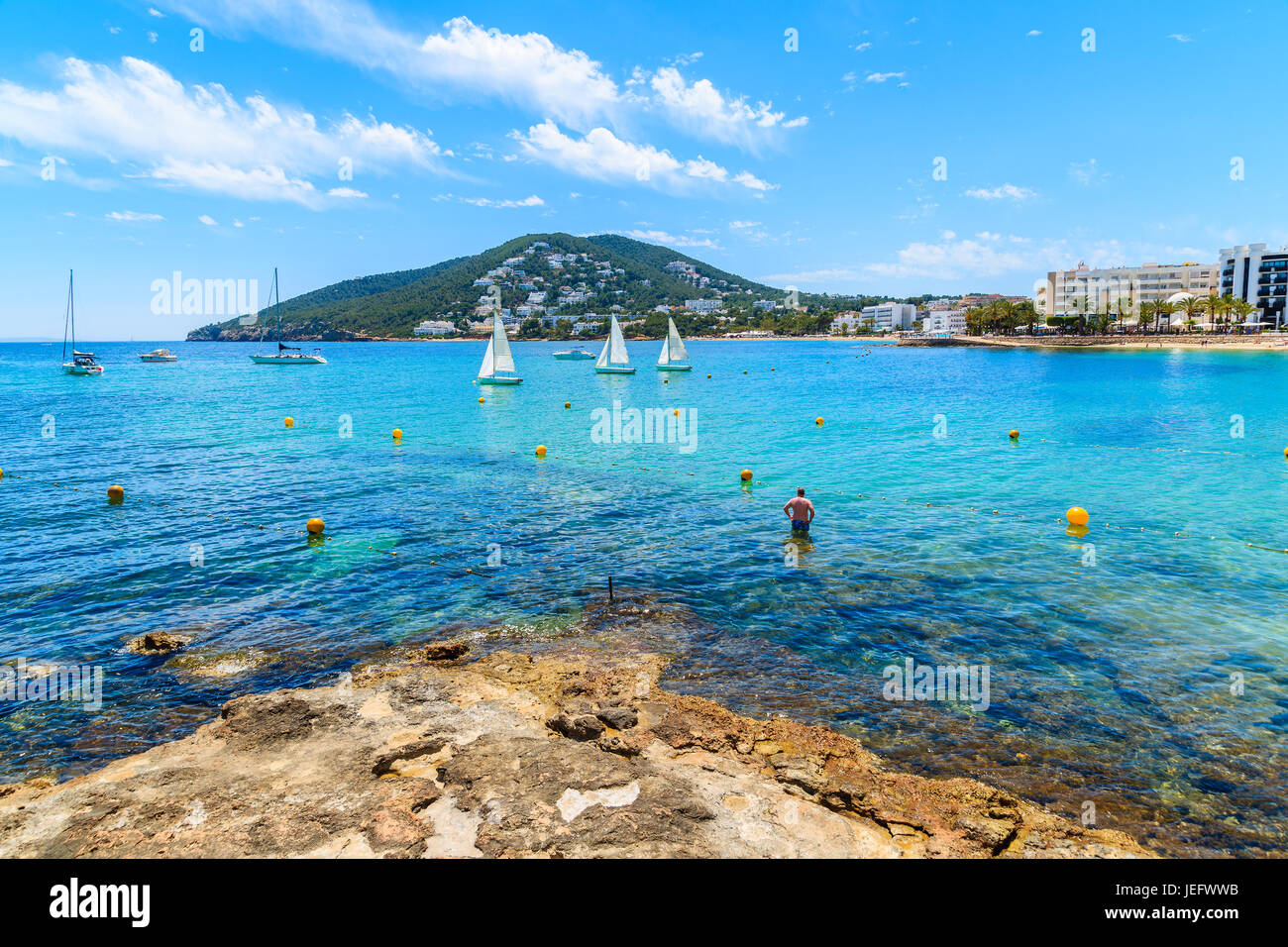 Unbekannter Mann stehend im Wasser am Strand von Santa Eularia, Insel Ibiza, Spanien Stockfoto