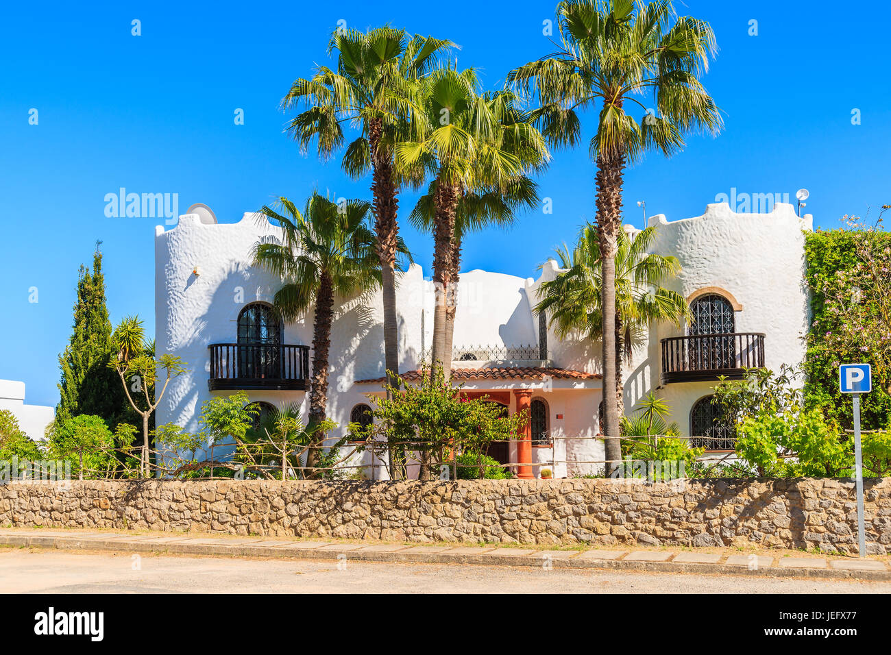 Insel IBIZA, Spanien - 20 Mai 2-17: Luxus-weiße Farbe-Ferien-Villa und hohen Palmen im Garten in Cala Nova Gegend der Insel Ibiza, Spanien. Stockfoto