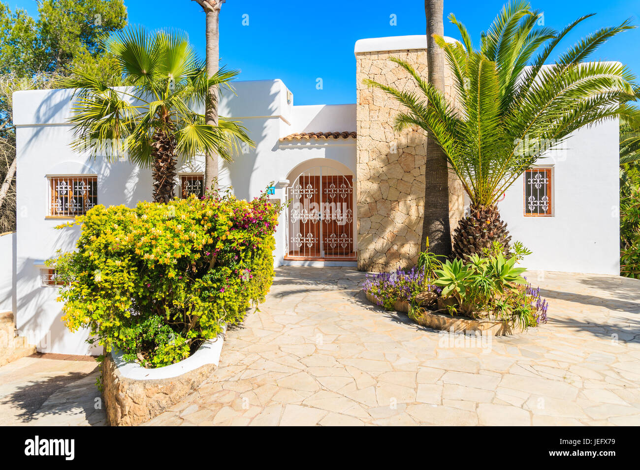 Insel IBIZA, Spanien - 20 Mai 2-17: Luxus weiße Farbe Urlaub Villa und Palmen Bäume im Garten in Cala Nova Gegend der Insel Ibiza, Spanien. Stockfoto