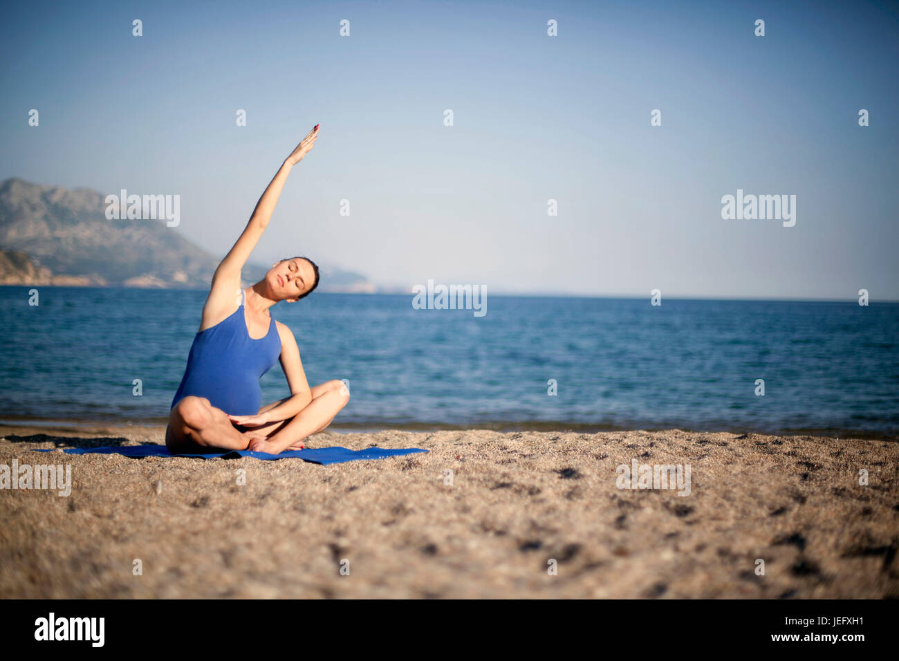 Junge schwangere Frau genießen in Yoga-Meditation am Strand Stockfoto