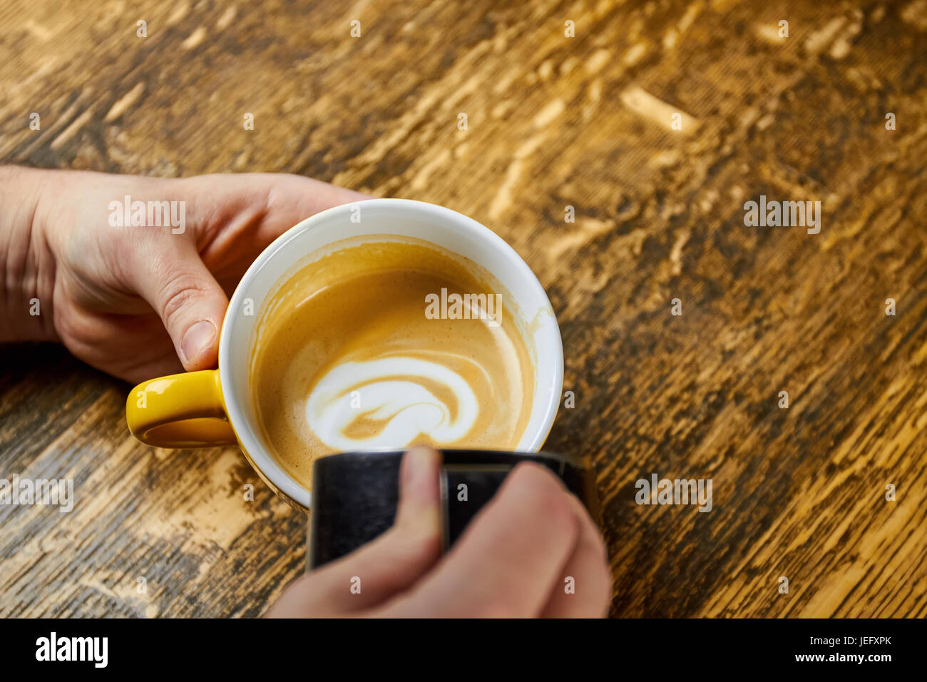 Händen Kaffee Milch hinzufügen. Stockfoto