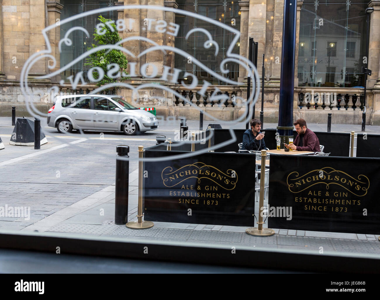 Newcastle-upon-Tyne, England, Vereinigtes Königreich.  Zwei Männer Überprüfung Handys bei einem Bier in Nicholson's The Victoria Comet Pub. Stockfoto