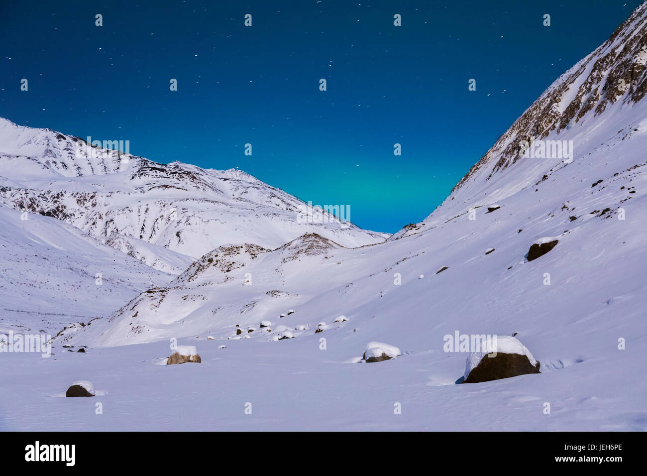 Eine sehr schwache Bande von Aurora erstreckt sich zwischen den Bergen an einem abgelegenen Ort im Bereich von Alaska im Winter, in der Nähe von Augustana Gletscher Stockfoto