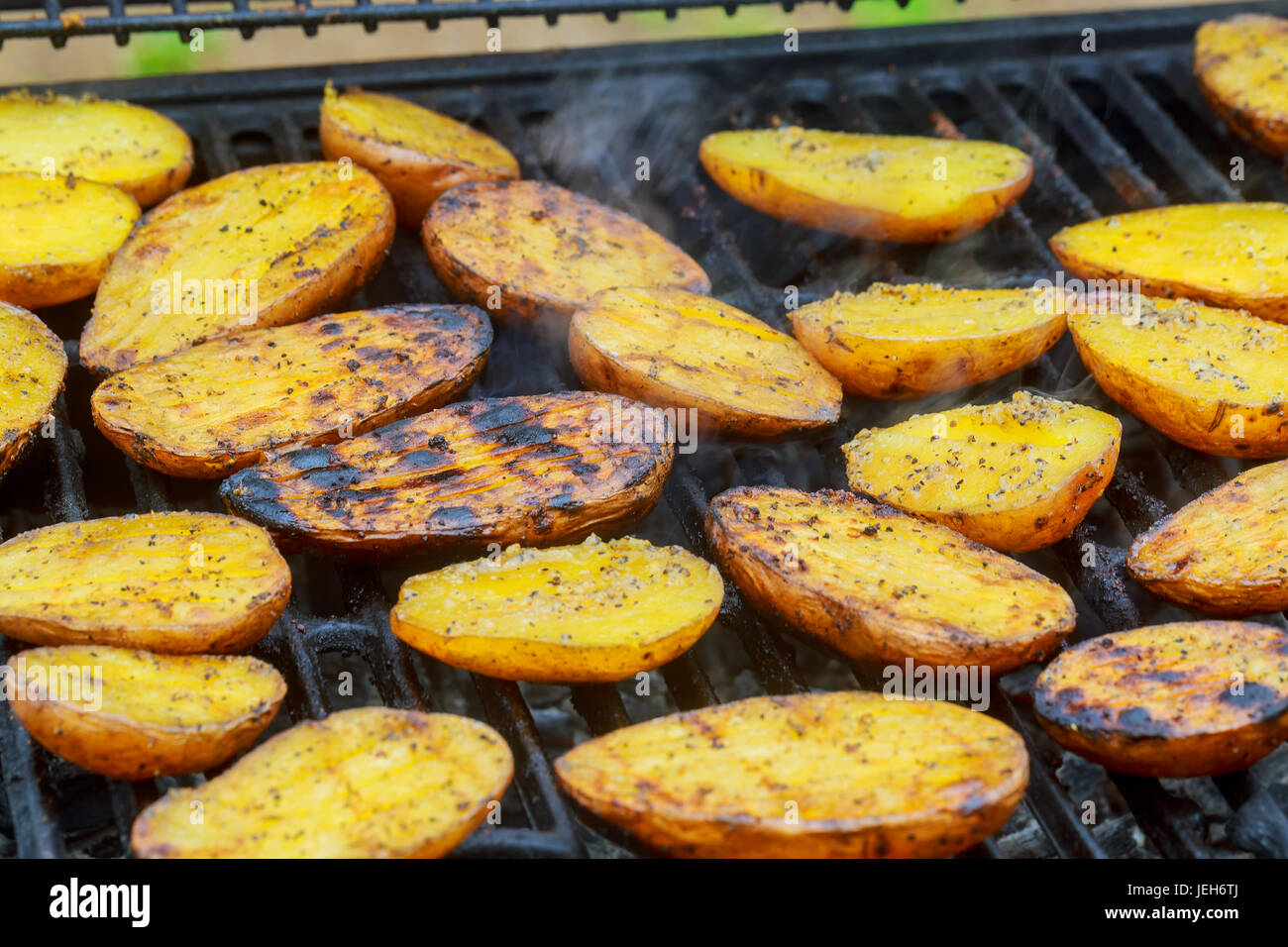 Leckere Kartoffeln auf Grill Grillen. Scheibe Kartoffel werden an sonnigen  Tag auf dem Grill zubereitet Stockfotografie - Alamy