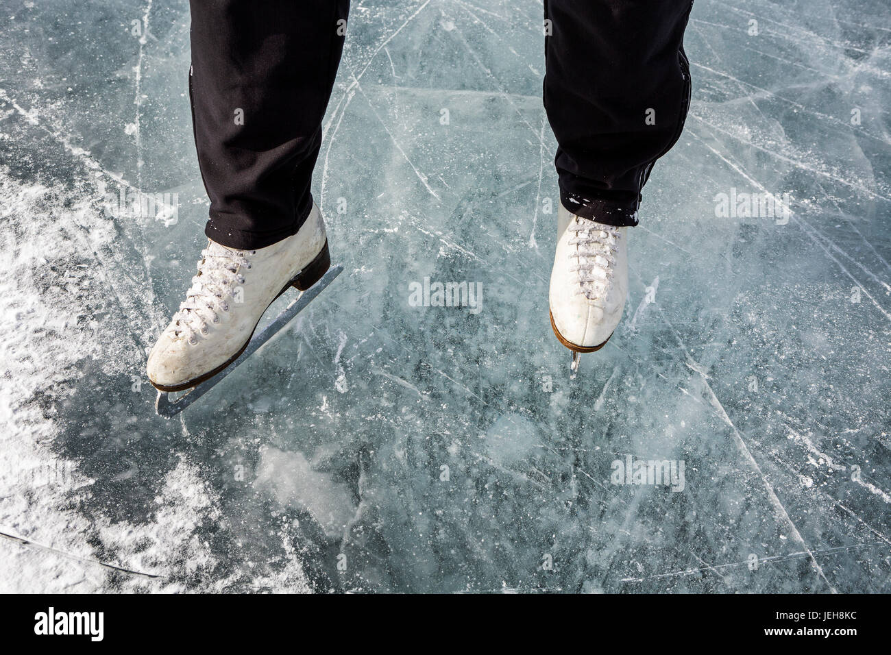 Erhöhte Ansicht und Nahaufnahme von weißen Schlittschuhen auf dem Eis; Calgary, Alberta, Kanada Stockfoto