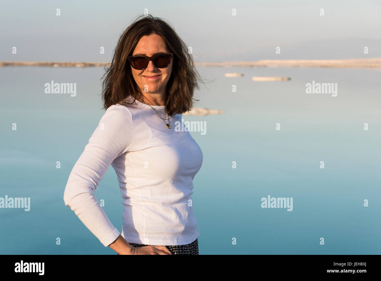 Porträt einer Frau das Tragen von Sonnenbrillen und stehen mit dem Toten Meer im Hintergrund; South District, Israel Stockfoto