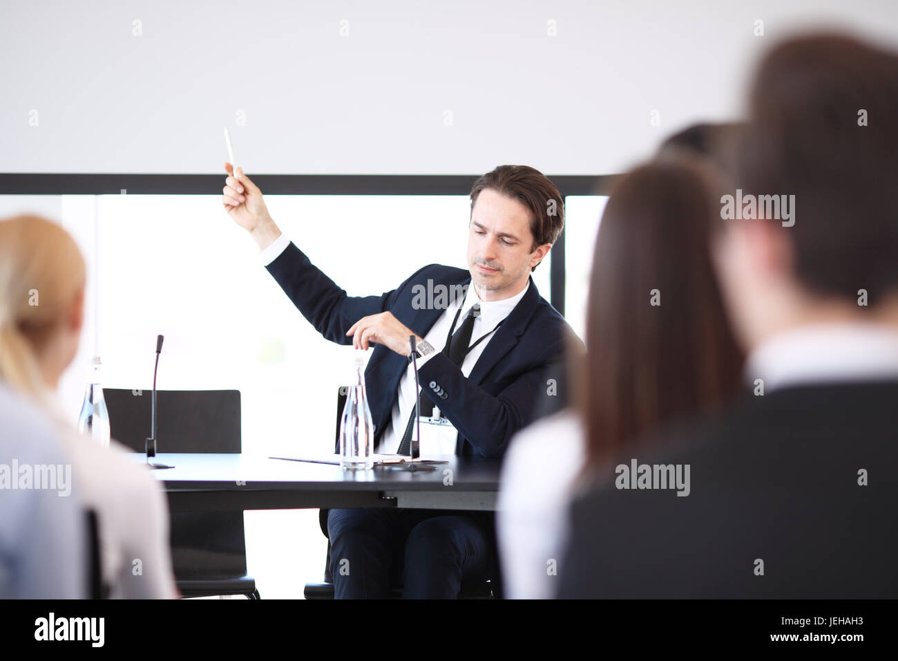 Sprechergruppe auf Business Meeting am Tisch mit Mikrofonen Stockfoto
