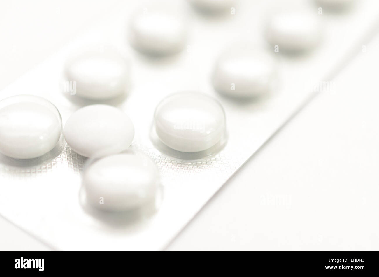 Empfängnisverhütende Tabletten in Paketen und ohne auf hellem Hintergrund. Stockfoto