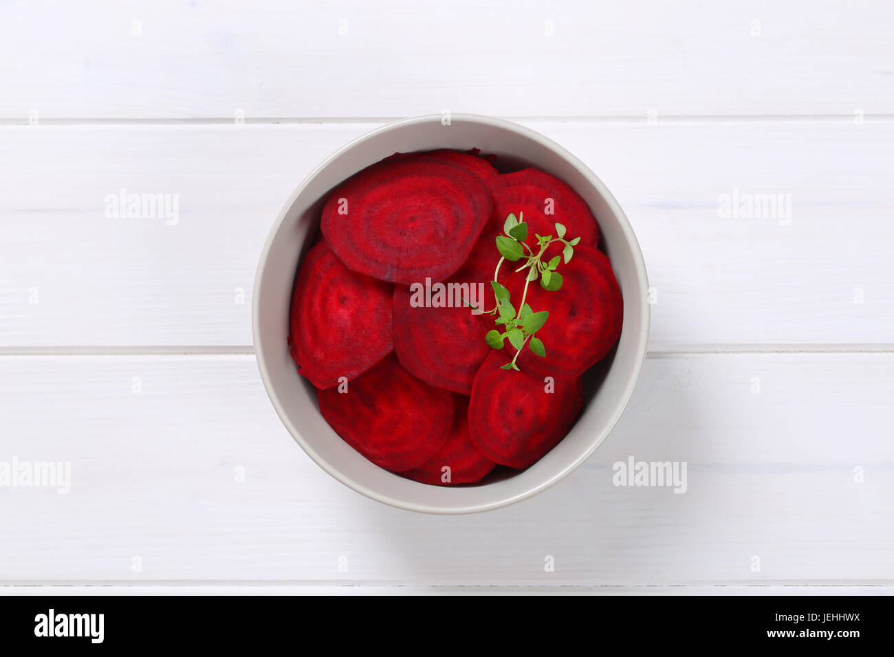 Schüssel mit dünne rote Beete Scheiben auf weißem Holz Hintergrund Stockfoto