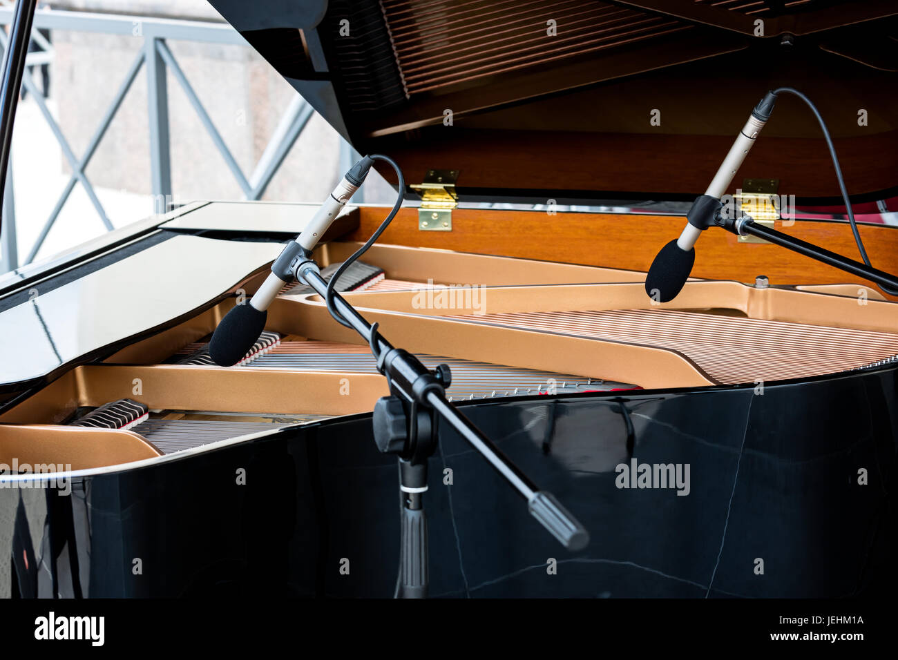 Klavier mit angehobenen Deckel. zwei Mikrofone über die Saiten der schwarzen Flügel. Stockfoto