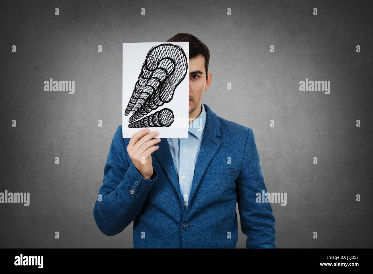 Porträt eines traurigen Geschäftsmann, versteckt die Hälfte seines Gesichts mit ein Weißbuch mit Fragezeichen gezeichnet. Traurig Student versteckt Gesicht mit vielen Fragen Mark. Stockfoto