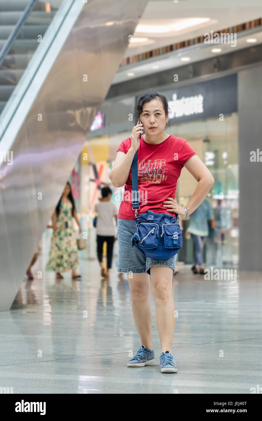 PEKING-AUG. 4, 2016. Frau Telefonat im Einkaufszentrum. Der chinesische Markt für mobiles Internet wird 717 mit 830 Millionen Nutzern über 2016 Milliarden US-Dollar liegen. Stockfoto