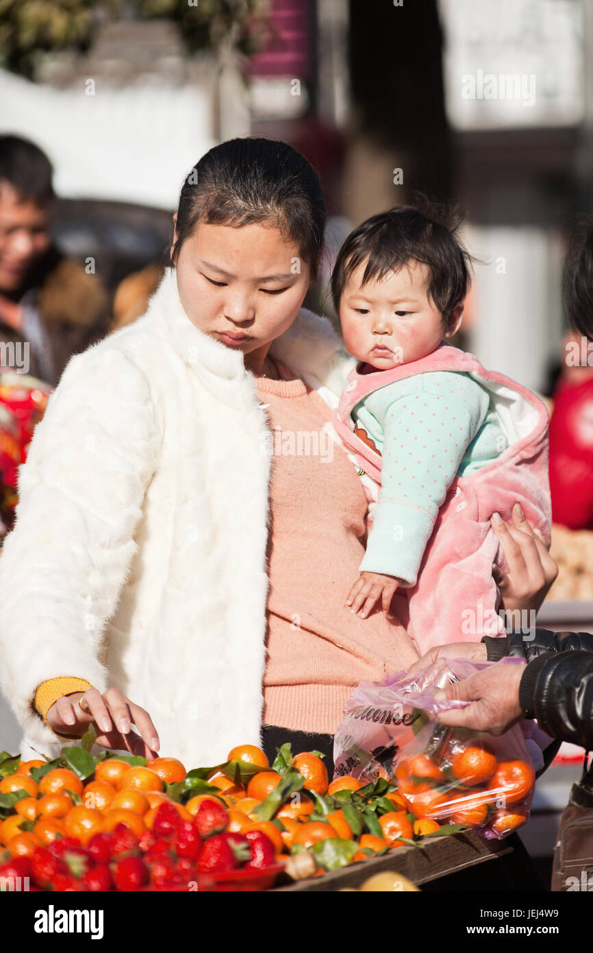 HENGDIAN-DEC. 29, 2015. Junge chinesische Mutter mit ihrem Kind. Die Kommunistische Partei Chinas kündigte 2013 an, die Ein-Kind-Politik zu lockern. Stockfoto