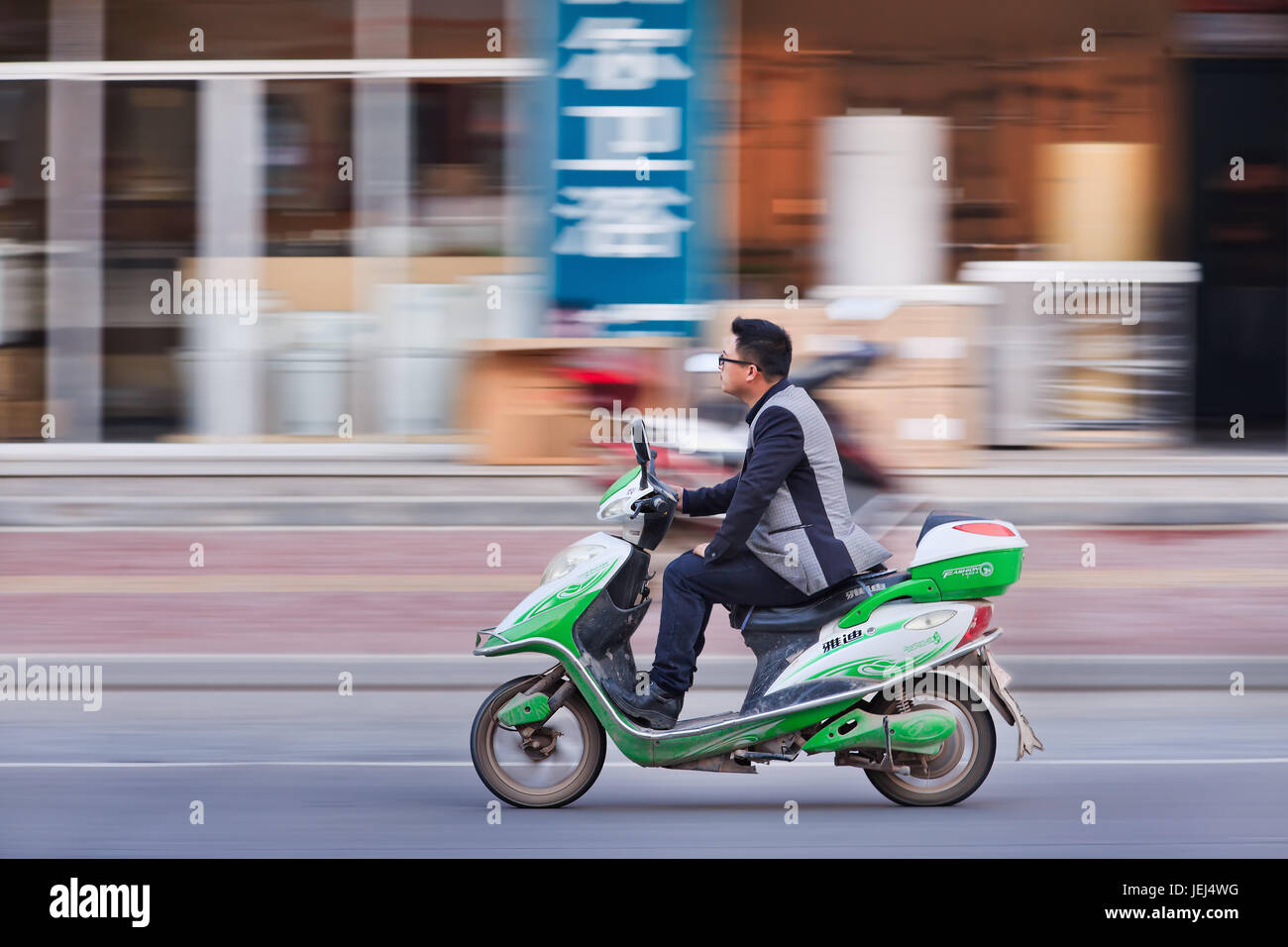HENGDIAN-JAN. 2, 2015. Junger Mann auf einem E-Bike. Schätzungsweise 200 Millionen Chinesen verwenden jetzt E-Bikes, 1.000-mal mehr als vor 15 Jahren. Stockfoto