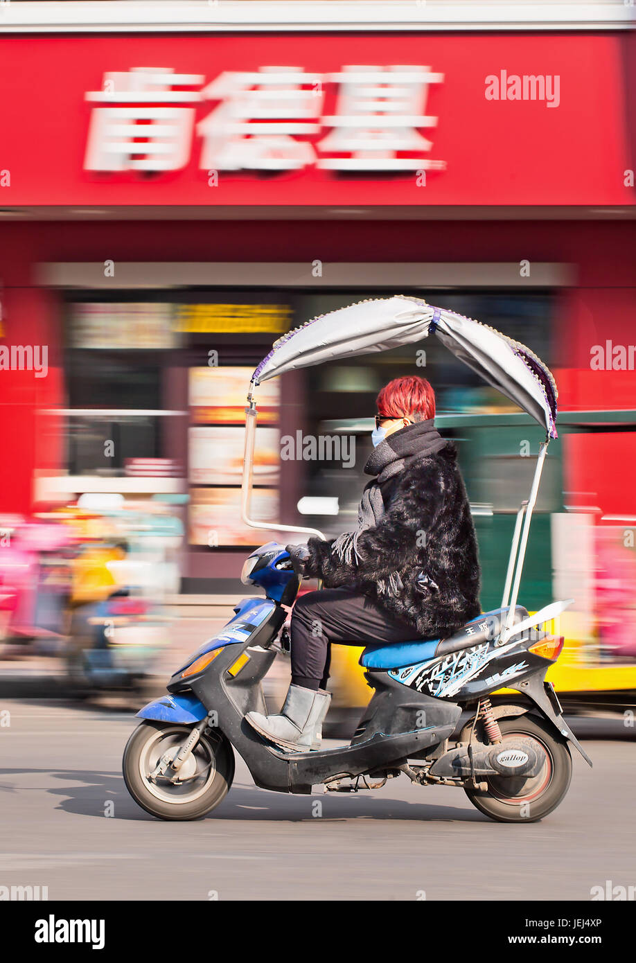 HENGDIAN-DEC. 29, 2014. Trendige Mädchen auf einem E-Bike. Schätzungsweise 200 Millionen Chinesen verwenden jetzt E-Bikes, 1.000-mal mehr als vor 15 Jahren. Stockfoto