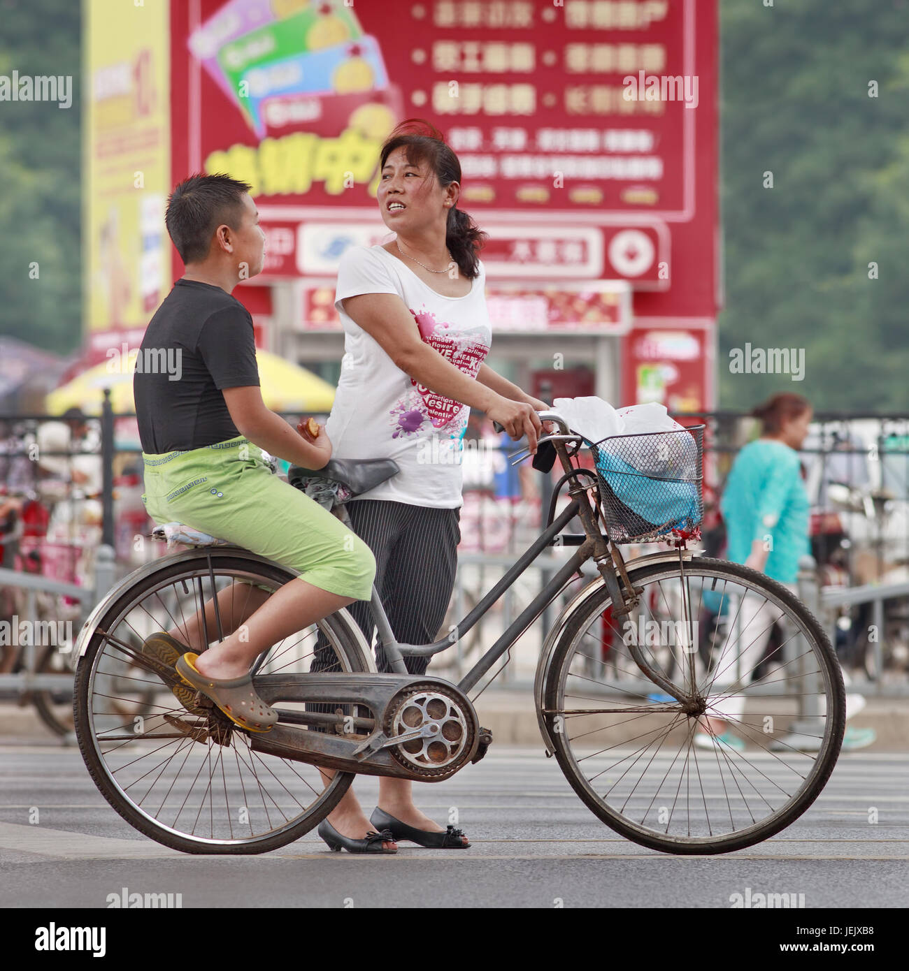 PEKING - 27. JULI 2015. Mutter mit ihrem fetten Sohn auf der Gepäckablage. Chinas Fettleibigkeit ist in den letzten Jahrzehnten in die Höhe geschossen. Stockfoto