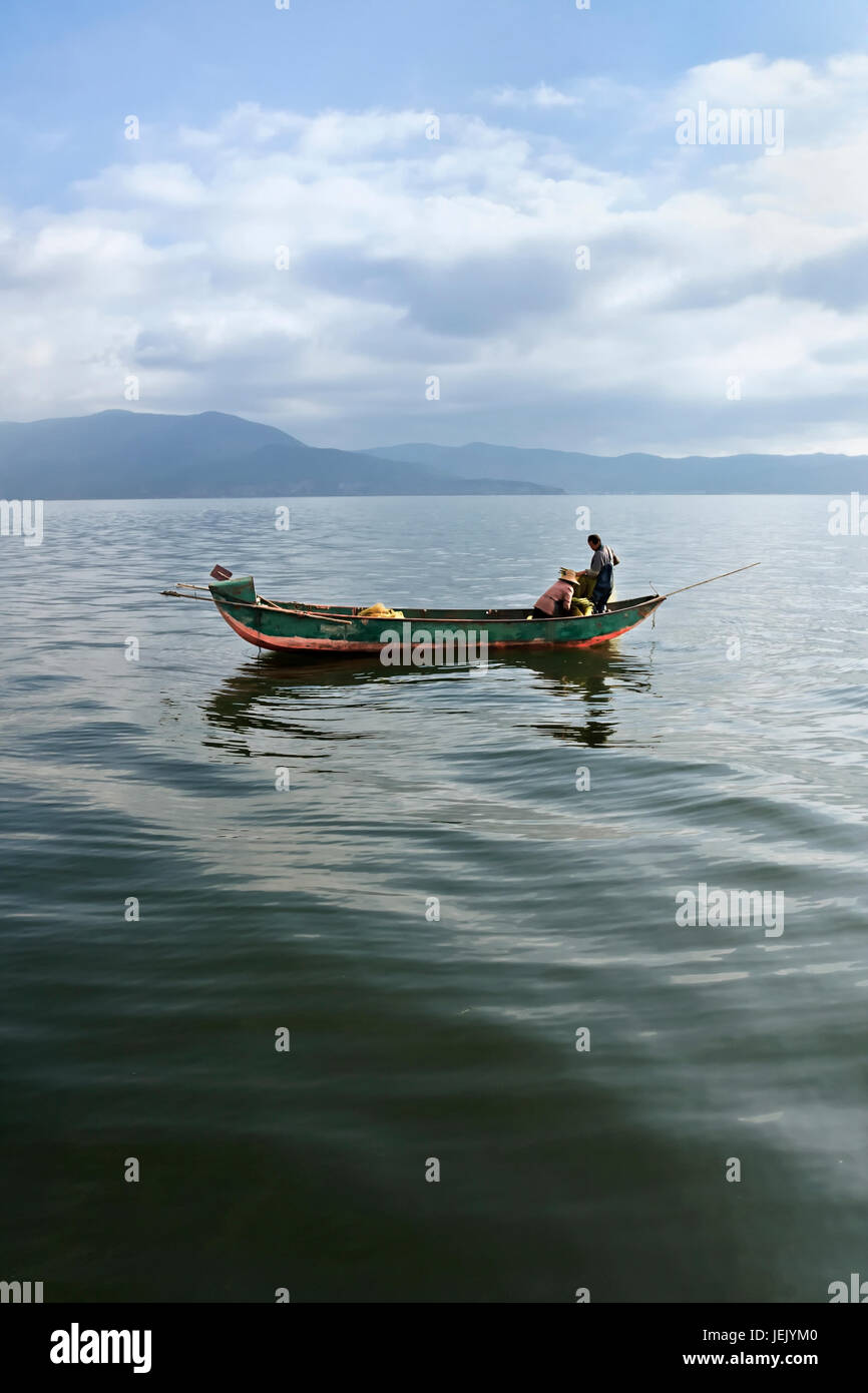 Zwei Personen in einem Fischerboot in den frühen Morgenstunden in Dali, Yunnan Provinz, China Stockfoto