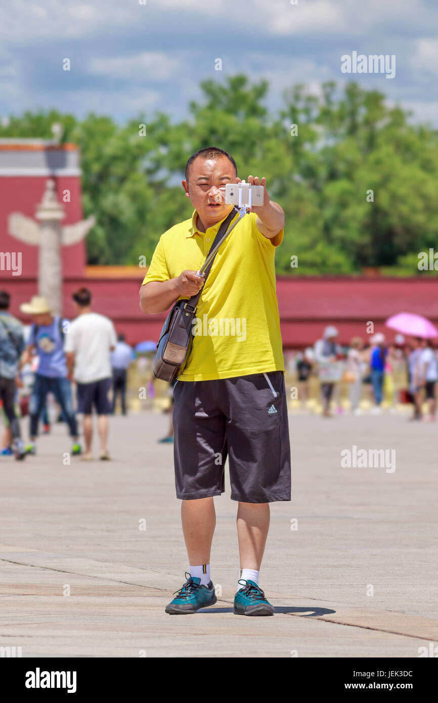 Der Mensch nimmt eine selfie an einem sonnigen Tiananmen Square, einem der größten Plätze der Welt (440,500 m2). Es hat eine große kulturelle Bedeutung. Stockfoto