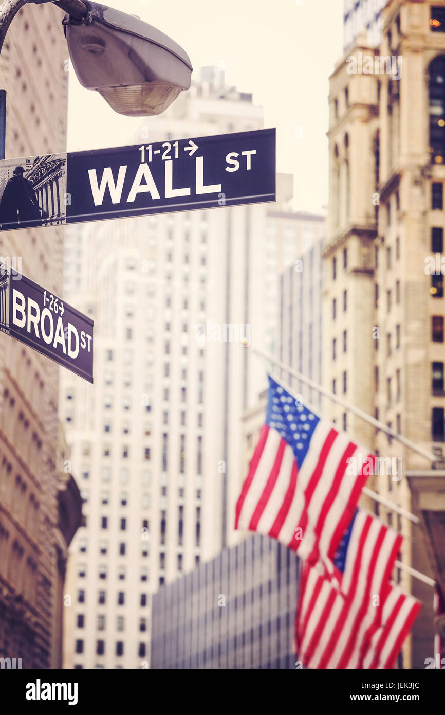 Wall Street und Broad Street Zeichen mit amerikanischen Flagge in Ferne, geringe Schärfentiefe, Farbe toning angewandte, New York City, USA. Stockfoto