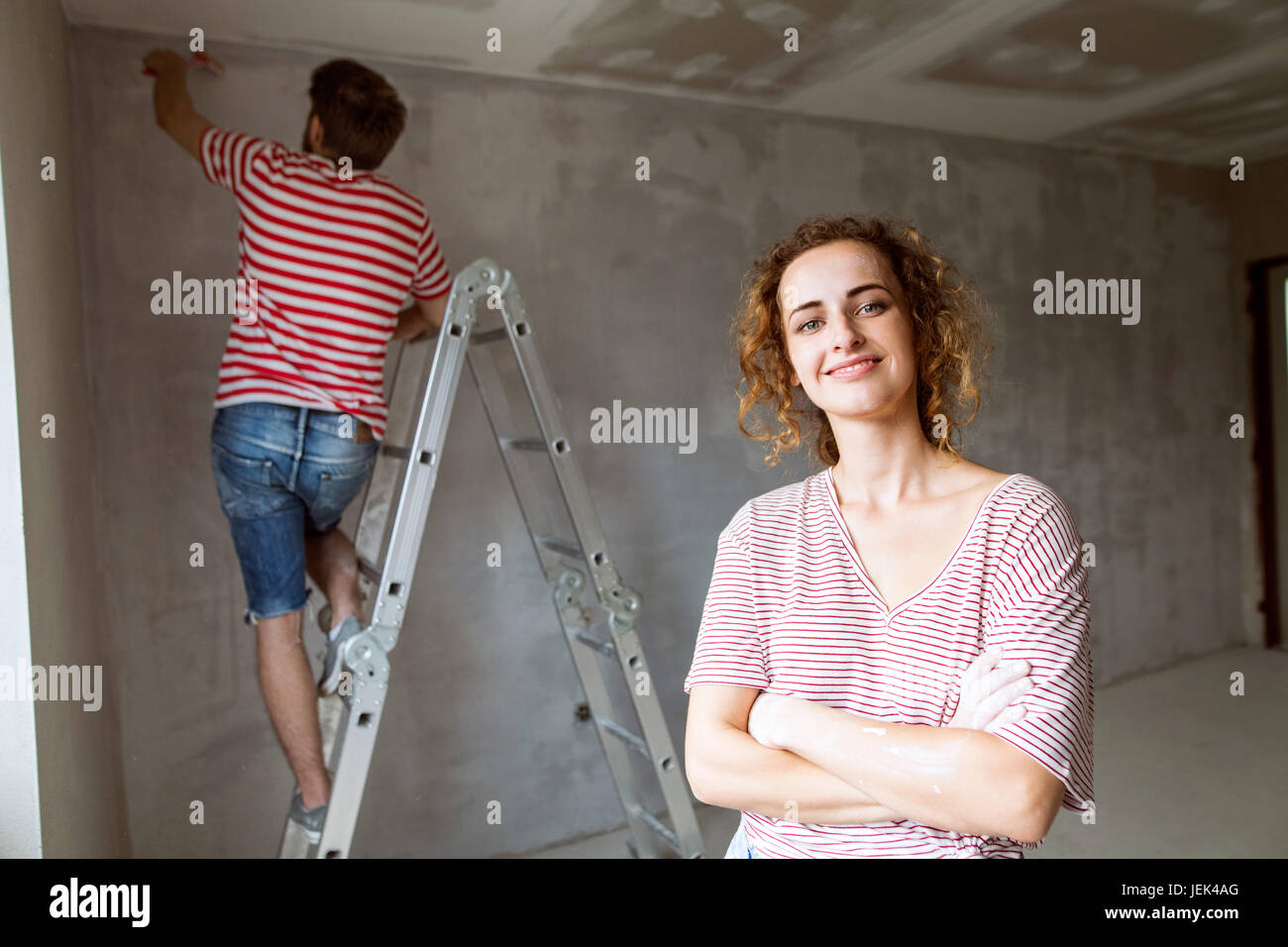 Junges Paar Malerei Wände in ihrem neuen Haus. Stockfoto
