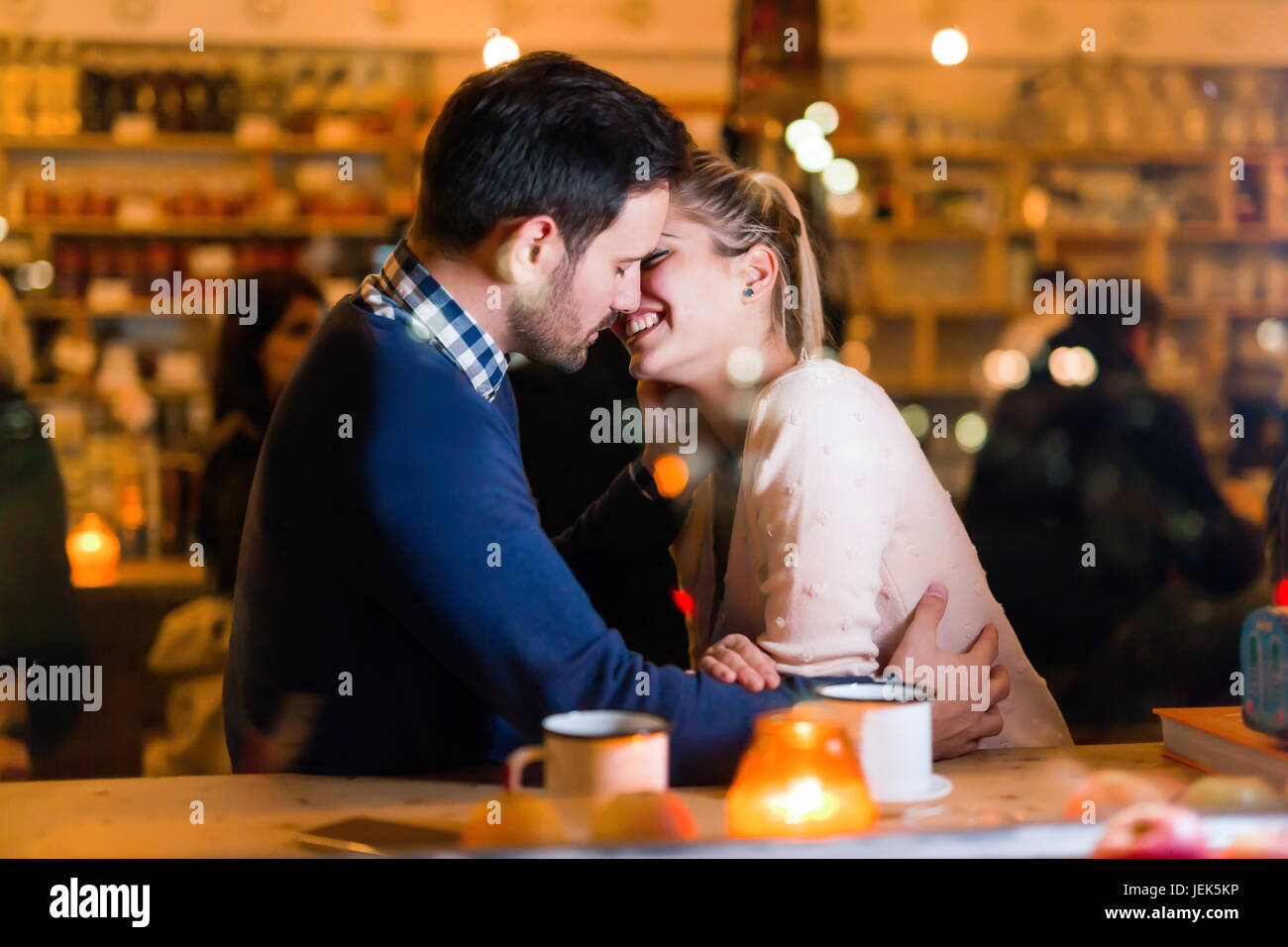 Attraktive Brautpaar küssen in bar mit Datum Stockfoto