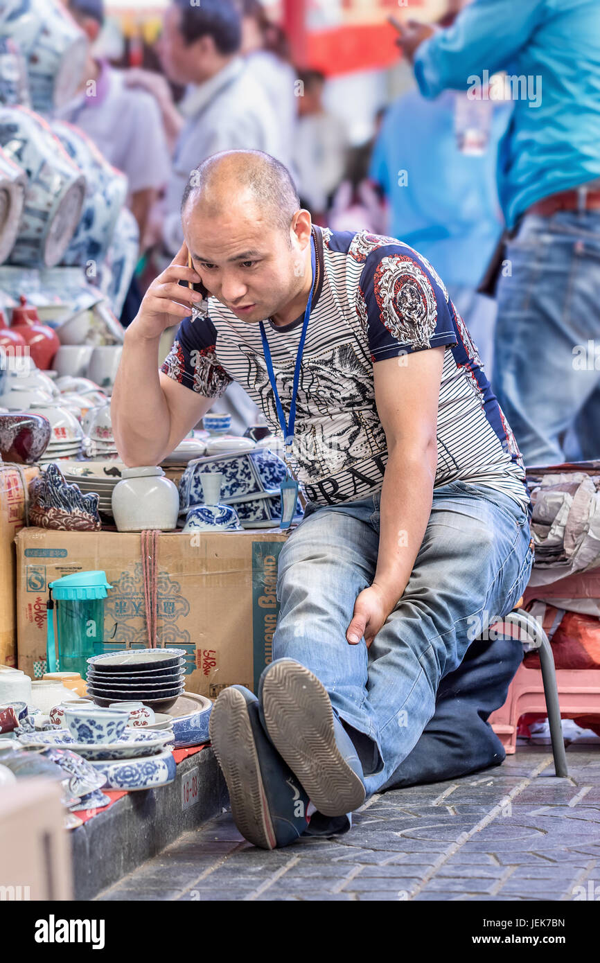 PEKING-29. MAI 2016. Verkäufer auf dem Panjiayuan Markt. Es ist der größte Markt, der Antiquitäten, Kunsthandwerk, Sammlerstücke und Dekorationen in China verkauft. Stockfoto