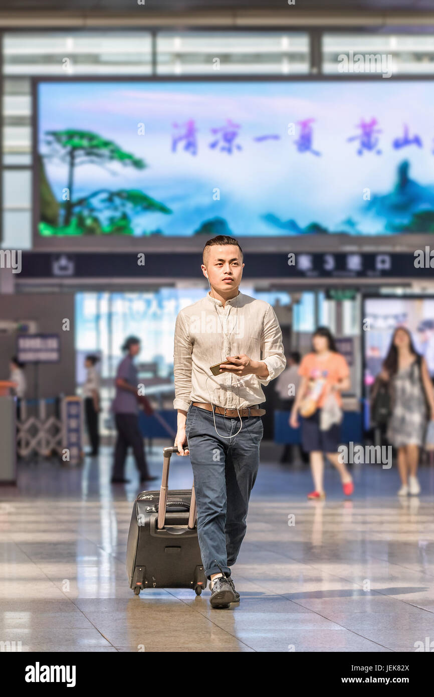 PEKING-21. MAI 2016. Junger Mann am Bahnhof Peking Süd, dem größten Bahnhof der Stadt, einer der größten in Asien, Endstation Hochgeschwindigkeitszüge. Stockfoto