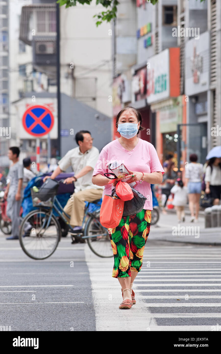 NANJING-MAI 25-2014. Frau mittleren Alters, die Mundkappe trägt. Immer mehr chinesische Bürger tragen Atemschutz. Stockfoto