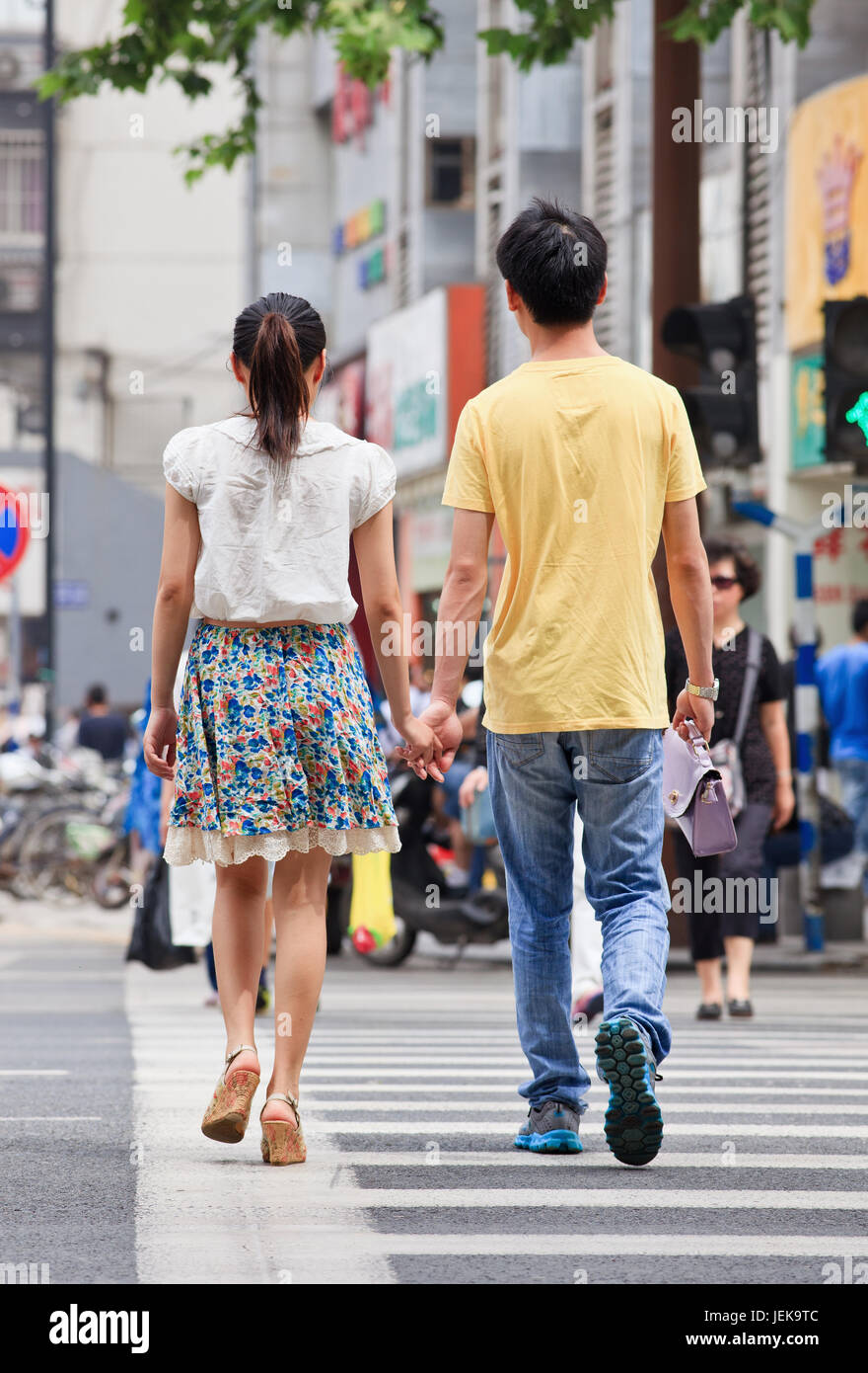 NANJING-MAI 25-2014. Jugendliches Paar geht Hand in Hand auf die Straße. Liebe, Romantik und Dating sind entmutigt, wenn Menschen jung sind. Stockfoto