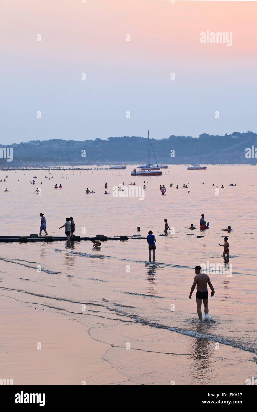 PENGLAI-CHINA-AUG. 14. Die Menschen genießen den Strand in der Dämmerung. Wegen des fairen Wetters sind ausgedehntere Küsten und berühmte Ziele Penglai sehr beliebt. Stockfoto
