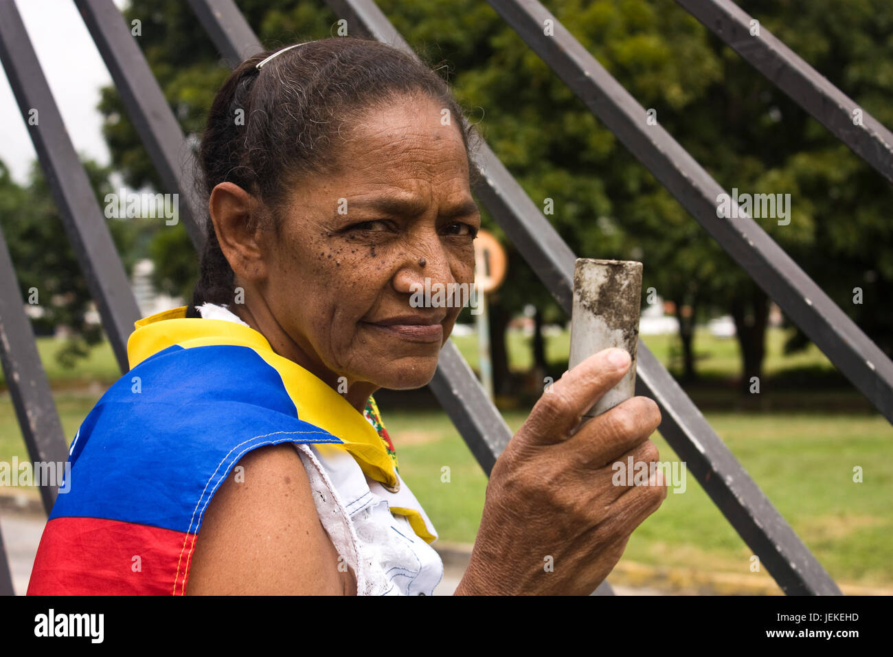 Eine alte Frau zu protestieren gegen die Regierung von Nicolas Maduro außerhalb von einem Militärflughafen in Caracas mit einem leeren Tränengas-Kanister. Stockfoto