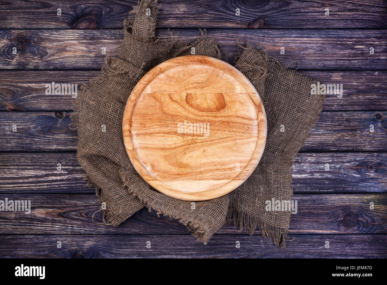 Rundes Tablett für Pizza auf dunklen Holztisch. Schneidebrett auf rustikalen Hintergrund. Ansicht von oben. Kopieren Sie Raum. Stockfoto
