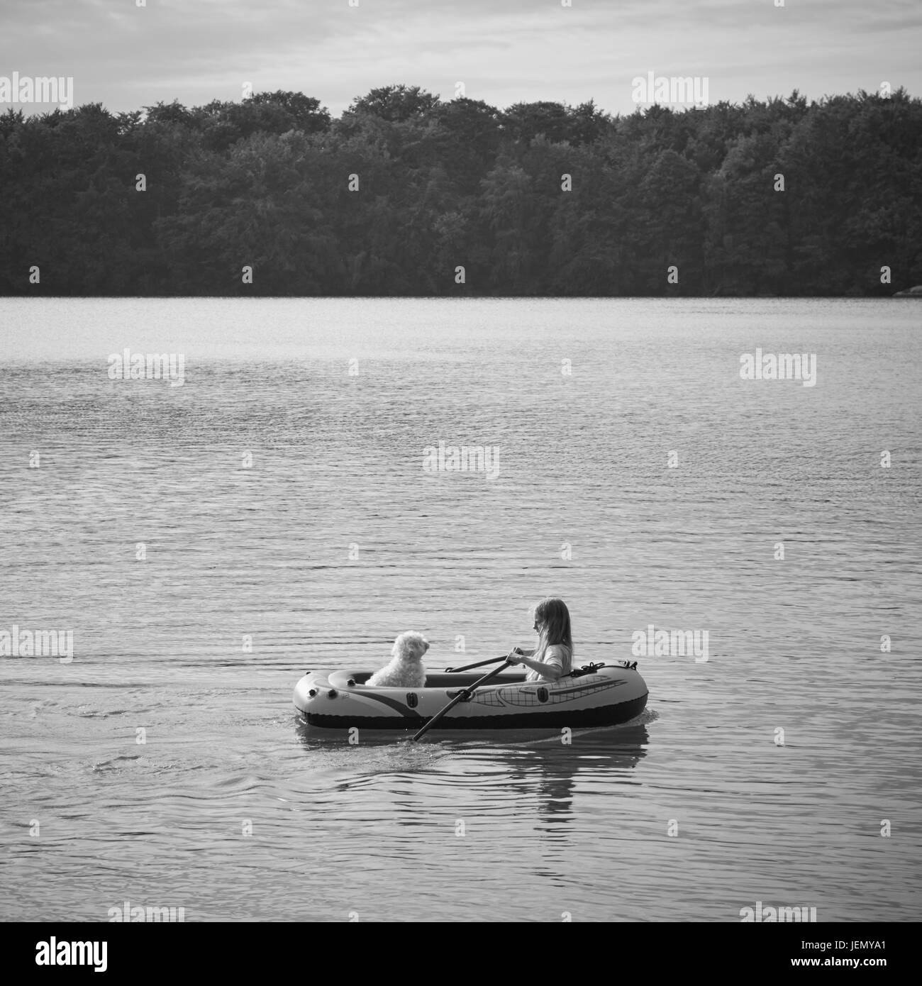 Mädchen mit Hund im Schlauchboot am See Stockfoto