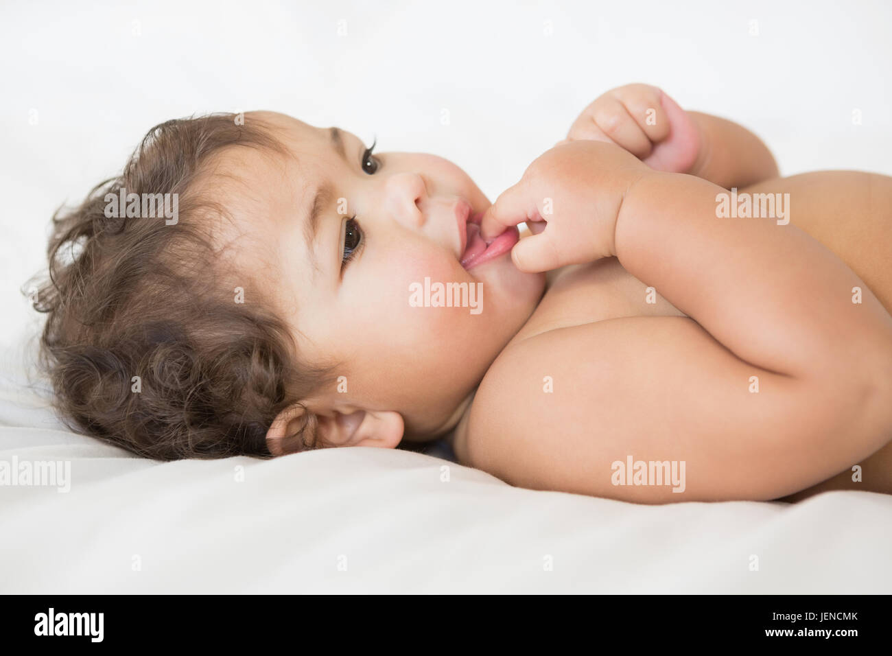 Smiling Baby mit Finger im Mund Stockfoto