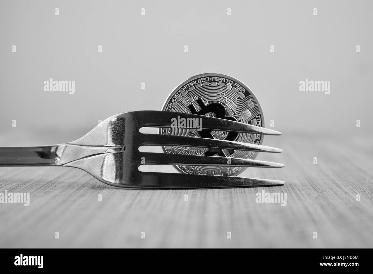 Kryptowährung physisches Silber Bitcoin Münze und Gabel auf Holzbrett. Stockfoto