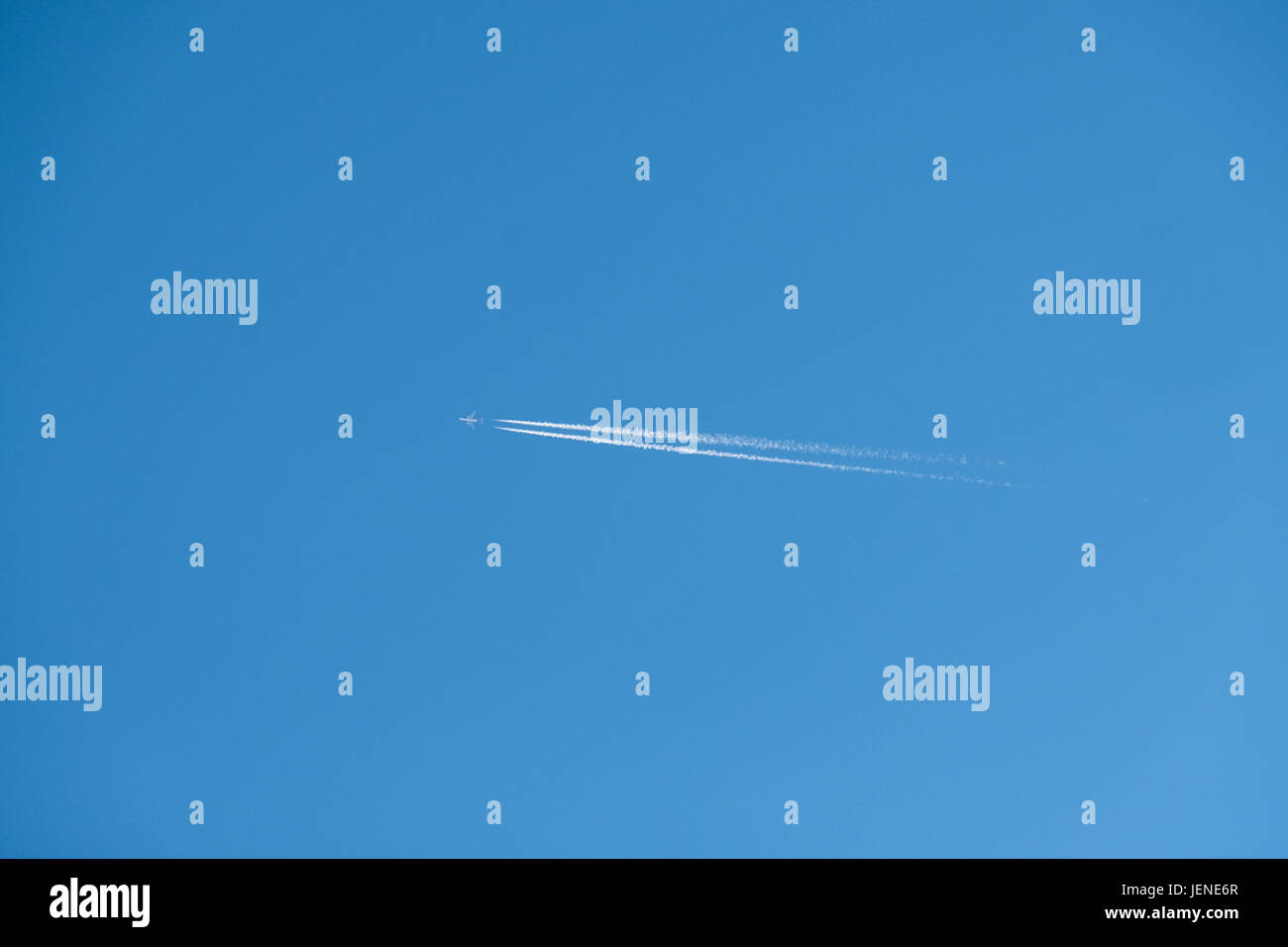 Flugzeug fliegen in den Himmel mit Kondensstreifen Stockfoto