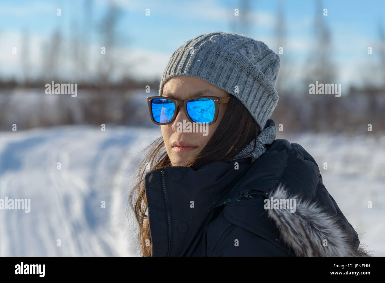 Porträt einer Frau im Schnee mit Sonnenbrille Stockfoto