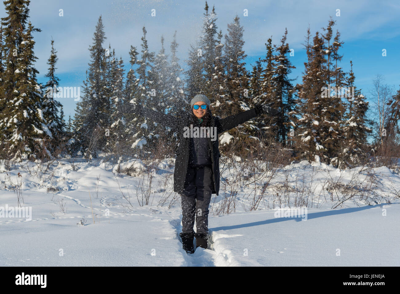 Lächelnde Frau mit Armen ausgestreckt stehen im Schnee, Yellowknife, Northwest Territories, Kanada Stockfoto