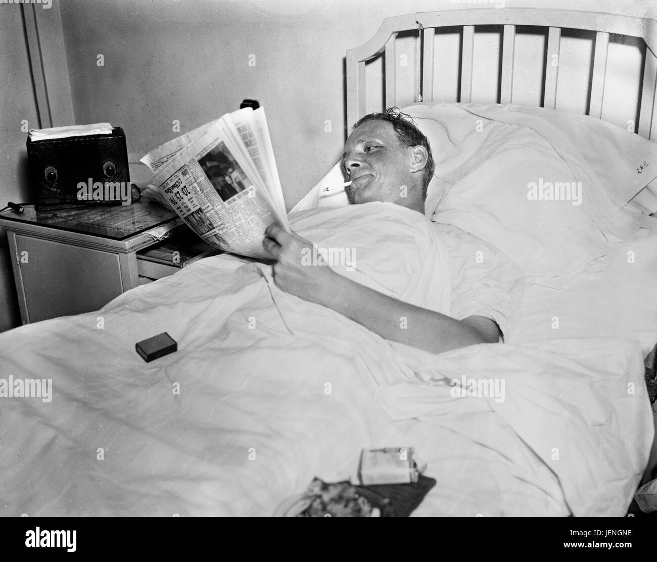 Mann Rauchen Zigarette beim lesen Zeitung im Krankenhaus-Bett Harris & Ewing, 1936 Stockfoto