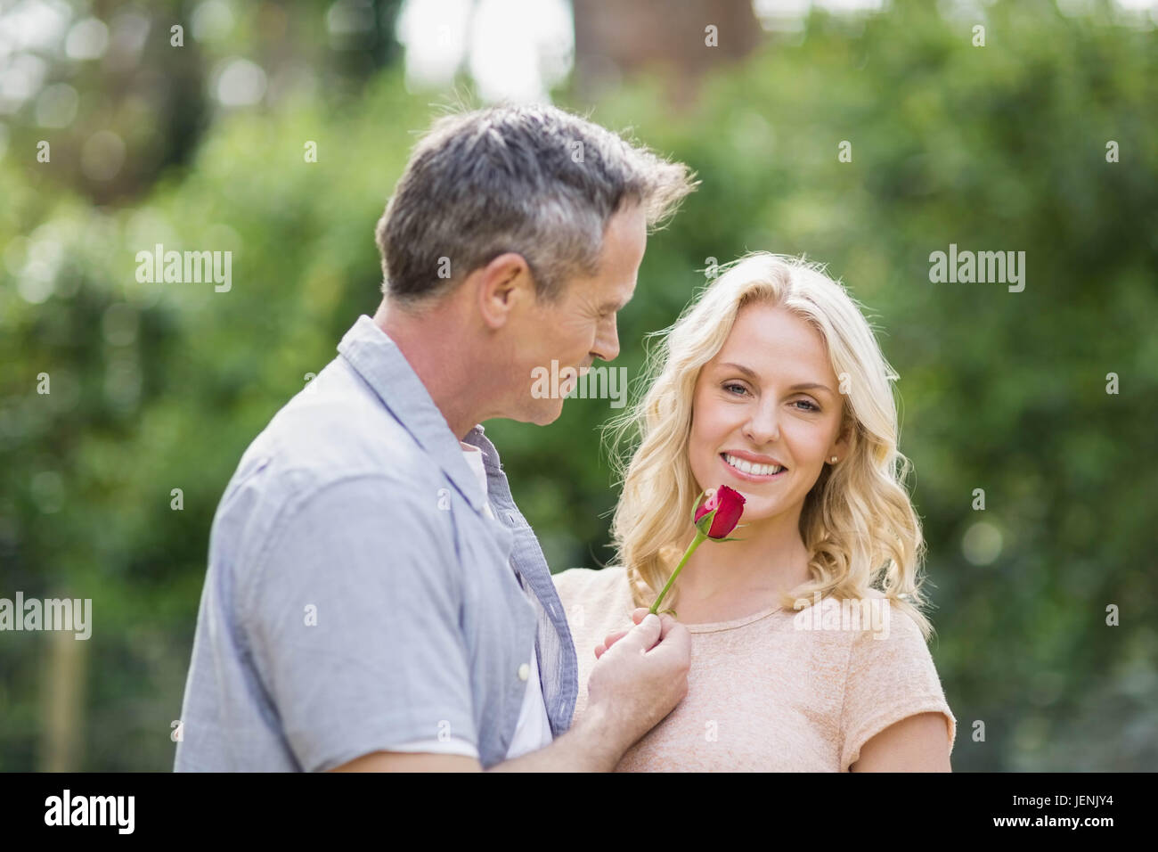 Mann, die Frau eine Rose anzubieten Stockfoto