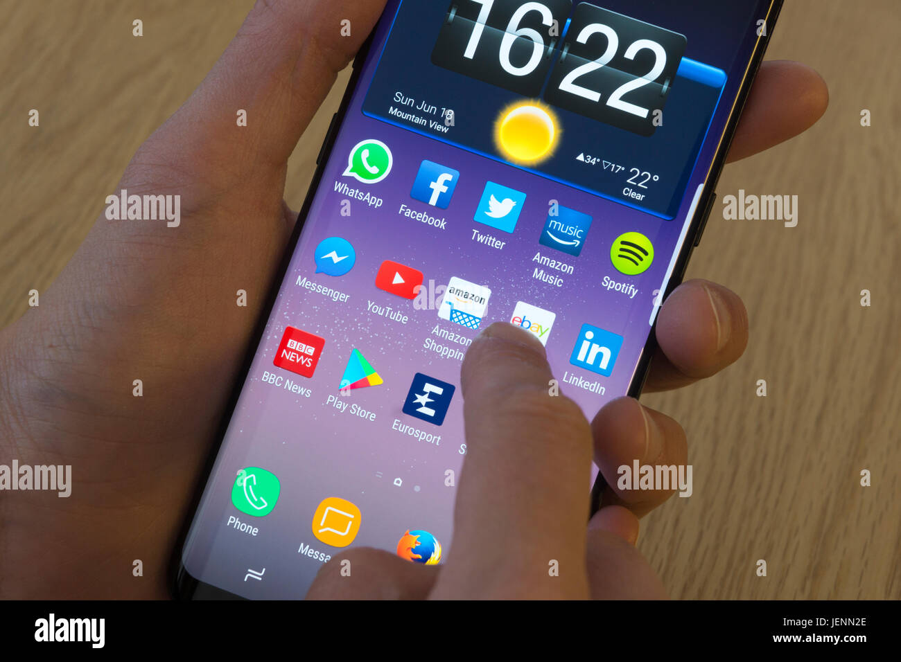 Eine junge Frau, die Amazon App auf einem smartphone Stockfoto