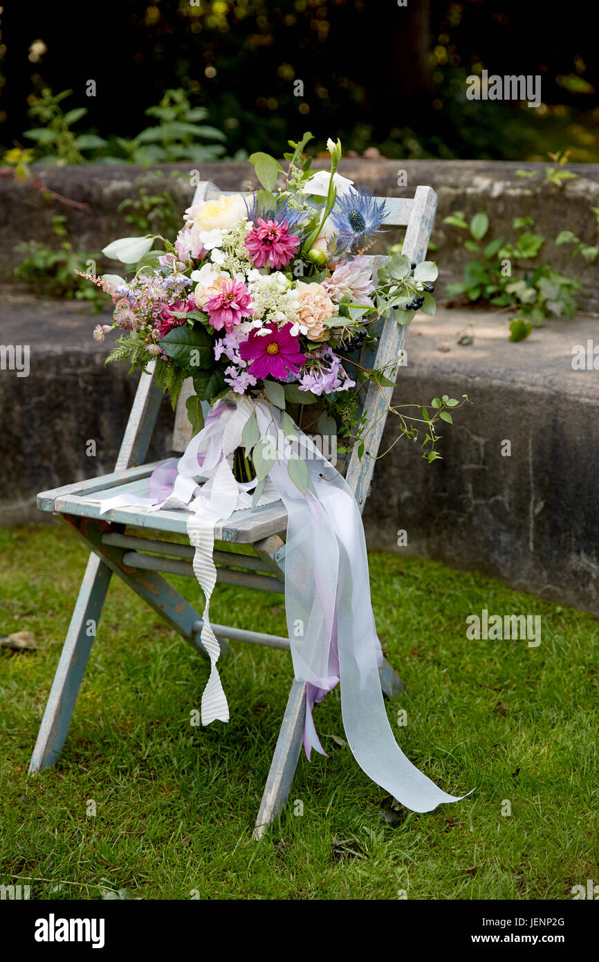Wedding Bouquet auf einem Stuhl im rustikalen Garten Stockfoto