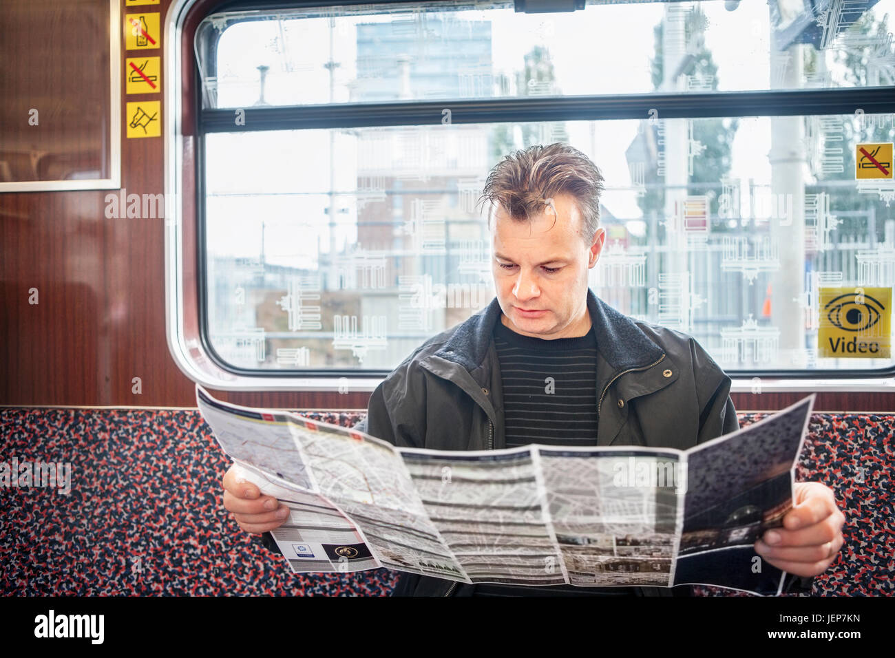 Mann liest Karte in Zug Stockfoto